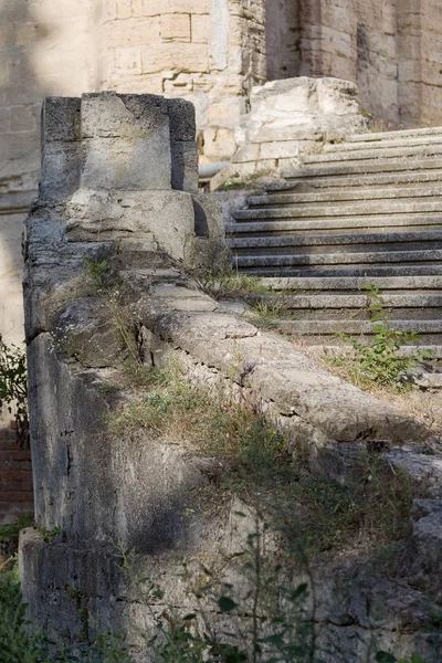 An old outdoor outdoor stone staircase. Stone, cement steps of old staircase with traces of weathering and destruction. Vintage stone staircase, ancient broken steps. Selective focu