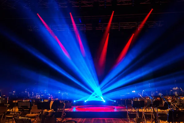 Stage lights. Background in the show. The light is in dark. The interior of the theater scene is illuminated by projector. Stage lights and smoke scenes during concert. Laser show on stage of theater