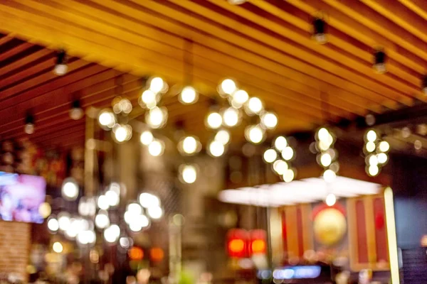 Küçük bir restoranın içi bulanık bir arka plan. Bokeh Kafe 'nin içini sıcak koyu renklerle bulanıklaştırmış. Yaratıcı moda tasarımı için arka plan olarak.