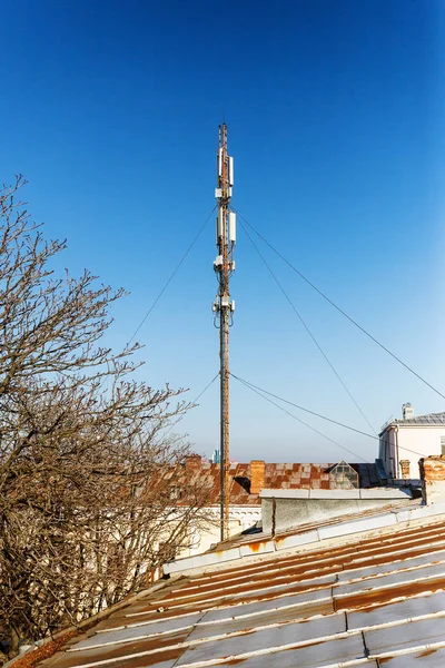 Network repeaters of telecommunication base stations on roof of building. An aerial of cellular communication on roof of building. Telecommunication tower of cell phone. Antennas on roof of building