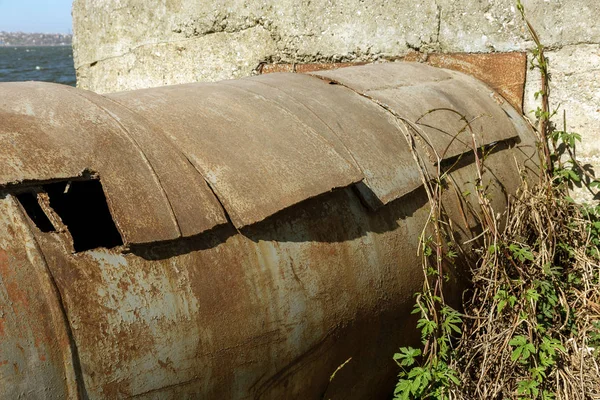 An old rusty large iron pipe of an outdated industrial waterpipe, Odessa, Ukraine, 2018. Large worn-out iron pipes for water supply of the city