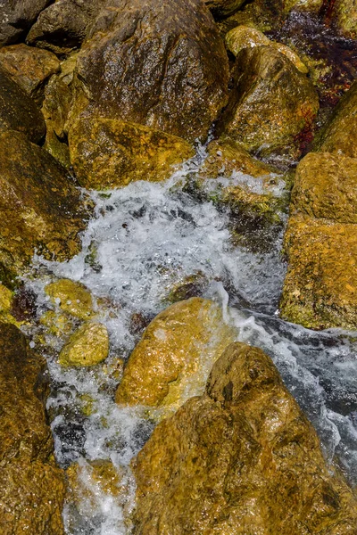 Büyük dalga sıçrama. Deniz suyu kayalar ve kayalıklarla karşı yenerek. Yukarıda ferahlatıcı güneş Zenit Beach'te mavi gökyüzü okyanus su damla.