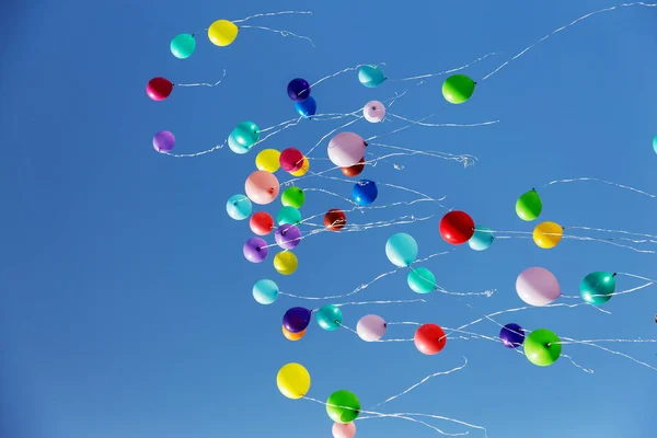 カラフルな多色インフレータブル ボール祭り祭りの期間中の木と青空の背景で空を飛ぶ カラフルな風船から空に敬礼 幸せな休日の背景 — ストック写真