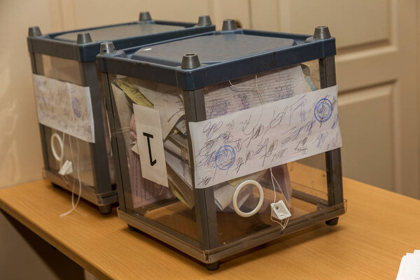 Odessa, Ukraine - 25 October 2015: a polling station during the elections of regional political local deputies and mayors. The voters take the ballots and cast into the sealed ballot box.