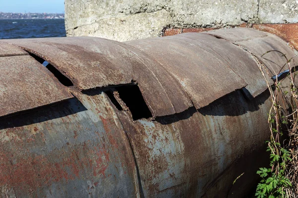 An old rusty large iron pipe of an outdated industrial waterpipe, Odessa, Ukraine, 2018. Large worn-out iron pipes for water supply of the city