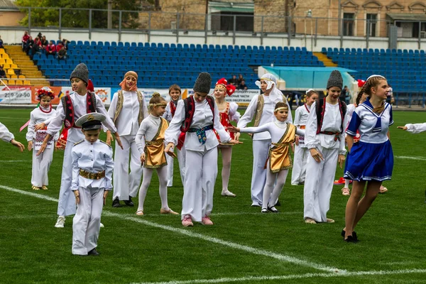 Odessa, Ukrayna - 21 Ekim 2017: Sahne alanı'nda çocuk. Genç çocuk topluluğu Stadyumu yeşil çimenlerin üzerinde Ulusal kostüm dans dans. Stadyumda dans çocuk
