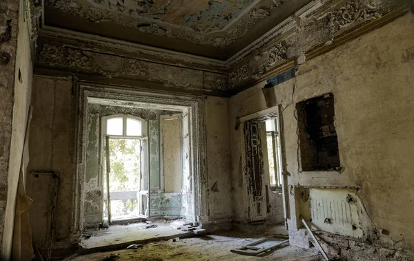 Mystical interior, ruins of an abandoned ruined building of an ancient 18th century building. Old ruined walls, corridor with garbage and mud. Destroyed molding, gypsum decorations, bas-relief