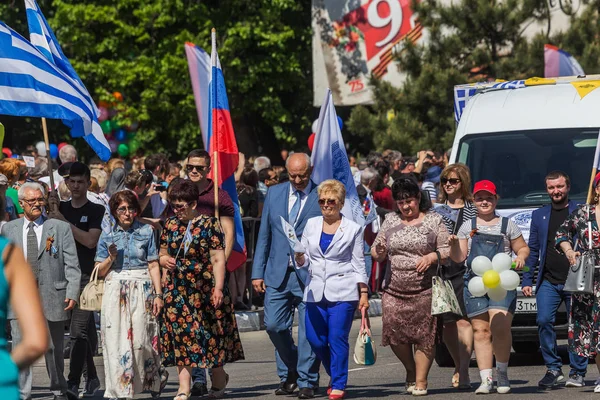 Novorossiysk, Rusya - 1 Mayıs 2018: Mayıs günü gösteri. Barış! İş! Mayıs! İnsanlar ile tatil geçit töreni sırasında Bayrak İşçi Bayramı kutlamak. 1 Mayıs günü tüm çalışan insanlar. Koloni içinde yürüyen insanlar