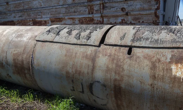 An old rusty large iron pipe of an outdated industrial waterpipe, Odessa, Ukraine, 2018. Large worn-out iron pipes for water supply of the city