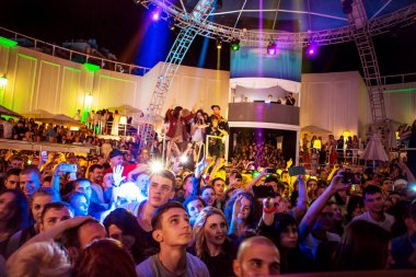 Odessa, Ukrayna - 24 Mayıs 2014: Kalabalık insan yaratıcı ışık ve müzik gösterisi sırasında bir konserde bir gece kulübünde eğleniyor. Konfeti ve büyük tiyatro kulübü parti üzerinde duman yağmuruna neşeli gençler.