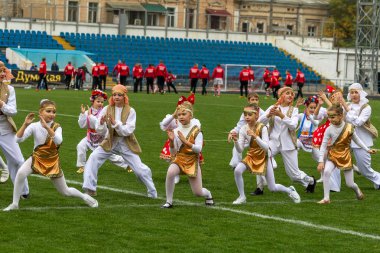 Odessa, Ukrayna - 21 Ekim 2017: Sahne alanı'nda çocuk. Genç çocuk topluluğu Stadyumu yeşil çimenlerin üzerinde Ulusal kostüm dans dans. Stadyumda dans çocuk