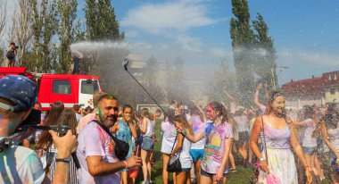 Odessa, Ukrayna - 5 Ağustos 2017: Gençler, bayanlar baylar bayram tatili sırasında birbirlerine renkli toz atma eğleniyorlar. Erkek ve kız ıslak giysileri içinde iyi eğlenceler. Islak parti