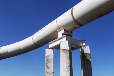 Dış boru tüp büyük boy petrol boru hattı. Rusça yazıt: tehlikeli yağdır. Büyük bükülmüş boru boru hattı özel malzeme ile izole. Yerden.