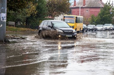 Odessa, Ukrayna - 21 Ekim 2015: büyük su birikintileri sokaklarında şiddetli yağışlar sonucu sular altında. Su ve kir yağmurda ıslak yolda ağır seyahat otomobil püskürtülür