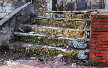 Eski, açık, taştan bir merdiven. Taş, eski merdivenlerin çimento basamaklarında yıpranma ve yıpranma izleri var. Eski taş bir merdiven, eski kırık basamaklar. Seçici odak