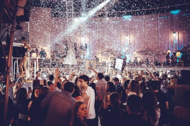 Odessa, Ukrayna - 24 Mayıs 2014: Kalabalık insan yaratıcı ışık ve müzik gösterisi sırasında bir konserde bir gece kulübünde eğleniyor. Konfeti ve büyük tiyatro kulübü parti üzerinde duman yağmuruna neşeli gençler.