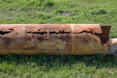 Eski büyük su boruları parçaları. Sonra uzun yıllar çalışma aşınmış metal boru yok. Paslı çelik boru delik metal korozyon ile. Seçici odak.