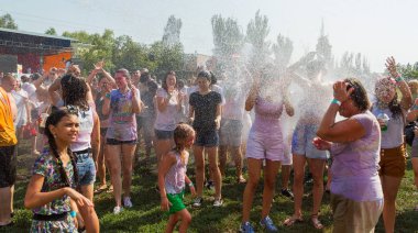 Odessa, Ukrayna - 5 Ağustos 2017: Gençler, bayanlar baylar bayram tatili sırasında birbirlerine renkli toz atma eğleniyorlar. Erkek ve kız ıslak giysileri içinde iyi eğlenceler. Islak parti