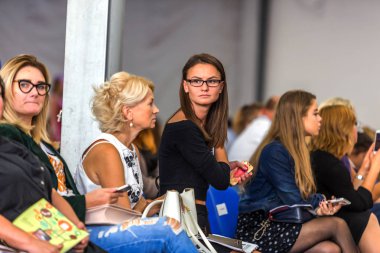 Odessa, Ukrayna, 3 Ekim 2015: Odessa Ofd moda haftası sırasında bir kadın moda seyirci göster. Yeni koleksiyon - 2015 Festivali moda. Vybrochny odak. Duygusal show hayranları