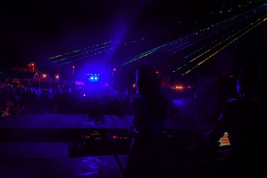 Lazer gösterisi. Gece kulübünde parti parlak performansı. Yaratıcı ışık gösterisi, siluetleri kalabalık dans pistinde. duman duman makinenin ışık resimde. Stilize film, tahıl, bozulma, hareket bulanıklığı