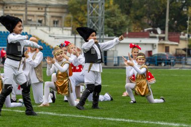 Odessa, Ukrayna - 21 Ekim 2017: Sahne alanı'nda çocuk. Genç çocuk topluluğu Stadyumu yeşil çimenlerin üzerinde Ulusal kostüm dans dans. Stadyumda dans çocuk