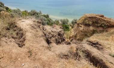 Çevreye zararlı bir bölgede dağ heyelan. Yeryüzündeki büyük çatlaklar, toprak yolu kapatan büyük katmanların inişi. Dağ yamacının yamacında baraj tehlikesi