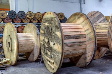 Güç elektrik kablo ve fiber optik üreten bir modern bitki içinde parçası. İç modern üretim hattı. Ulaşım ve tüketici güç kalın metal kablo satışı için büyük ahşap ambalaj makaraları
