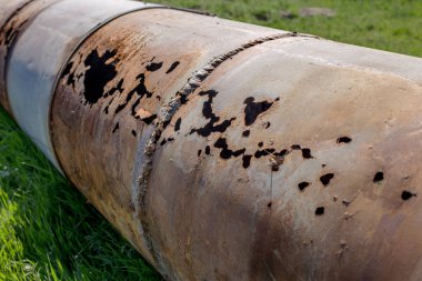 Eski büyük su boruları parçaları. Sonra uzun yıllar çalışma aşınmış metal boru yok. Paslı çelik boru delik metal korozyon ile. Seçici odak.