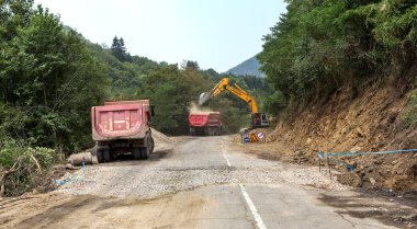 Rila Manastırı, Bulgaristan - 30 Temmuz 2016: dağ yolu genişletmek için inşaatı işi. Modern yol yapım ekipmanları çalışır. Dar geçit. Kapalı yol. Karayolu onarım çalışmaları