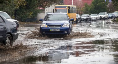 Odessa, Ukrayna - 21 Ekim 2015: büyük su birikintileri sokaklarında şiddetli yağışlar sonucu sular altında. Su ve kir yağmurda ıslak yolda ağır seyahat otomobil püskürtülür