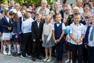 Odessa, Ukrayna 1 Eylül 2017: Okul bahçesinde öğrenciler ve öğretmenler ile okul çizgi var. Çocuklar okula geri dön. Bilgi gün, okulun ilk günü. Birinci sınıf öğrencileri sınıfta oturmak