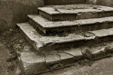 Eski, açık, taştan bir merdiven. Taş, eski merdivenlerin çimento basamaklarında yıpranma ve yıpranma izleri var. Eski taş bir merdiven, eski kırık basamaklar. Seçici odak