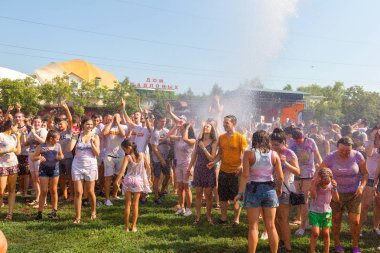 Odessa, Ukrayna - 5 Ağustos 2017: Gençler, bayanlar baylar bayram tatili sırasında birbirlerine renkli toz atma eğleniyorlar. Erkek ve kız ıslak giysileri içinde iyi eğlenceler. Islak parti