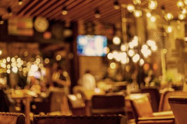 Küçük bir restoranın içi bulanık bir arka plan. Bokeh Kafe 'nin içini sıcak koyu renklerle bulanıklaştırmış. Yaratıcı moda tasarımı için arka plan olarak.