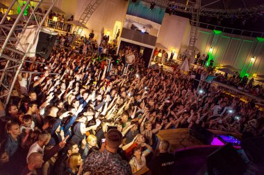 Odessa, Ukrayna - 24 Mayıs 2014: Kalabalık insan yaratıcı ışık ve müzik gösterisi sırasında bir konserde bir gece kulübünde eğleniyor. Konfeti ve büyük tiyatro kulübü parti üzerinde duman yağmuruna neşeli gençler.