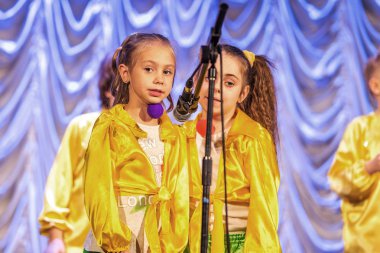 Odessa, Ukrayna - 24 Aralık 2015: şarkı ve parlak renkli kıyafetler içinde sahnede dans çocuk müzik grupları. Duygusal, çocukların müzik sahne gösterisi dokunmadan.