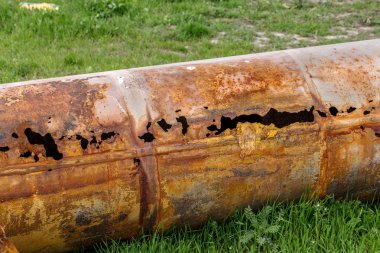 Eski büyük su boruları parçaları. Sonra uzun yıllar çalışma aşınmış metal boru yok. Paslı çelik boru delik metal korozyon ile. Seçici odak.