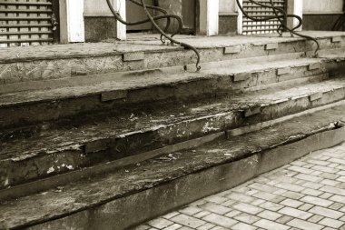 Eski, açık, taştan bir merdiven. Taş, eski merdivenlerin çimento basamaklarında yıpranma ve yıpranma izleri var. Eski taş bir merdiven, eski kırık basamaklar. Seçici odak