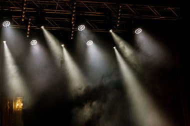 Sahne ışıkları. Arka planda göstermek. Karanlığın içinde bir ışık var. Tiyatro sahne iç projektör ile aydınlatılır. Sahne ışıkları ve duman sahneleri konser sırasında. Lazer gösterisi sahne tiyatro