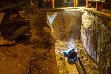 Odessa, Ukrayna - 10 Aralık 2015: inşaat işçileri Acil Onarım kentsel Karayolları geceleri mühendislik yapıyor. Onarım ve yedek su, Kanalizasyon borular alt kısmında derin bir siper gece boyunca. Kaza.