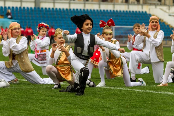 Odessa, Ukrayna - 21 Ekim 2017: Sahne alanı'nda çocuk. Genç çocuk topluluğu Stadyumu yeşil çimenlerin üzerinde Ulusal kostüm dans dans. Stadyumda dans çocuk