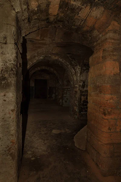 An old abandoned tunnel in an underground wine cellar. Entrance to catacombs. Dungeon Old stone fortress. As creative background for staging dark design. Mystical interior of ancient dungeon