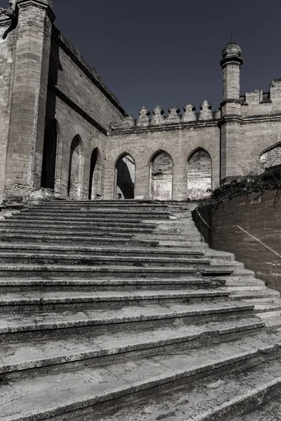 An old outdoor outdoor stone staircase. Stone, cement steps of old staircase with traces of weathering and destruction. Vintage stone staircase, ancient broken steps. Selective focu