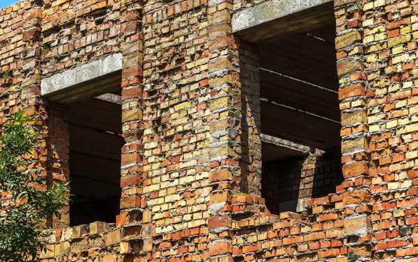 Ruined wall of building. Abandoned to unnecessary houses are destroyed. Self-destruction of abandoned buildings. Conceptually, crisis, migration, war. Brick house is destroyed. Window and wall are broken