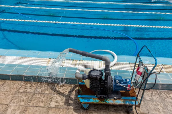 Cleaning the sports pool with a cleaning water pump. The water pump filters the water from the bottom of the pool, cleans from dirt and debris. The cleaning pump works with the pool.