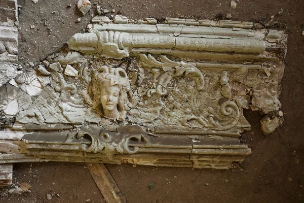 Mystical interior, ruins of an abandoned ruined building of an ancient 18th century building. Old ruined walls, corridor with garbage and mud. Destroyed molding, gypsum decorations, bas-relief