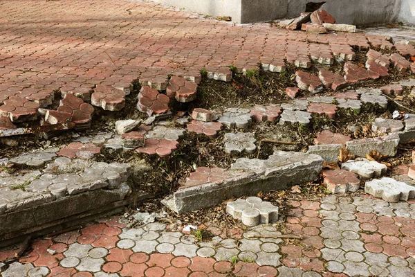 An old open outer stone staircase. Stone, cement steps of the old staircase with traces of weathering and destruction. An ancient stone staircase, ancient broken worn steps. Selective focus