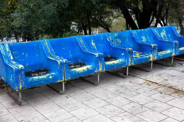 Empty old plastic chairs for spectators. Number of empty seats in old small place. Scratched worn blue plastic seats for important fan visitors. Rows of plastic fiberglass chairs on platform ferry bus