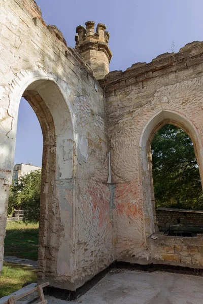 Mystical interior, ruins of facade of abandoned ruined building of ancient castle, mansion. Old ruined walls, corridor with garbage and mud. Ruins Ancient historical building, destroyed by vandals