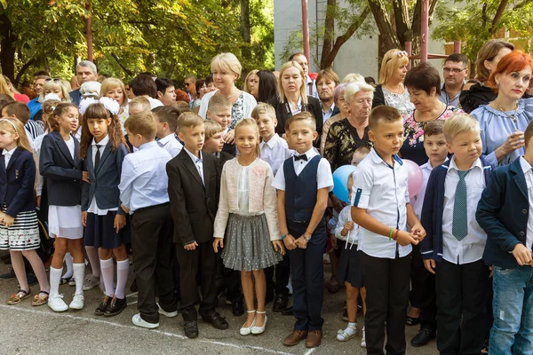 Odessa, Ukrayna 1 Eylül 2017: Okul bahçesinde öğrenciler ve öğretmenler ile okul çizgi var. Çocuklar okula geri dön. Bilgi gün, okulun ilk günü. Birinci sınıf öğrencileri sınıfta oturmak